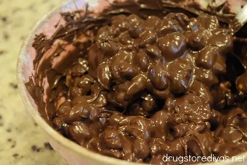 Melted chocolate and peanuts in a pink bowl.