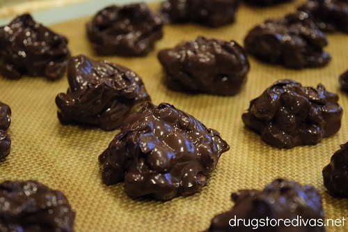 Chocolate peanut clusters on a baking mat.