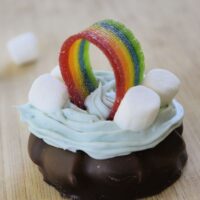 A cookie made to look like a pot of gold with a rainbow on top and the words 