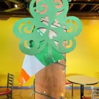 A shamrock on a pole with an Irish flag behind it and the words 
