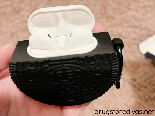 An Oreo Cookie shaped airpod holder with the airpods showing at the top.