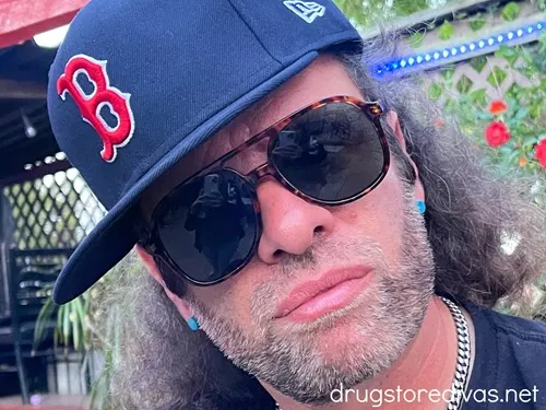 A man wearing a Boston Red Sox baseball cap and sunglasses.