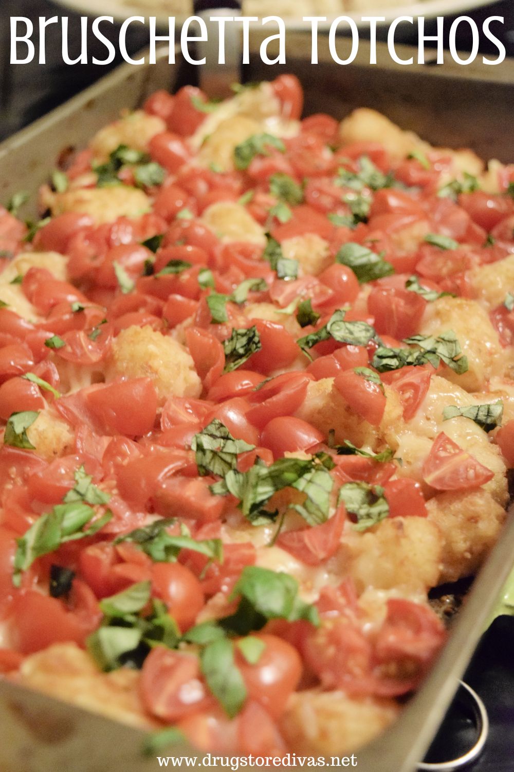 Tater tots with cheese, tomatoes, and basil in a pan with the words 