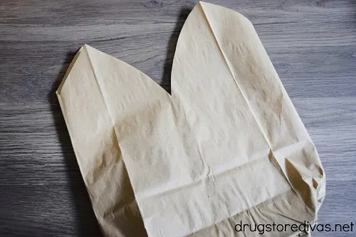 A flattened paper lunch bag with two rounded triangles up top.