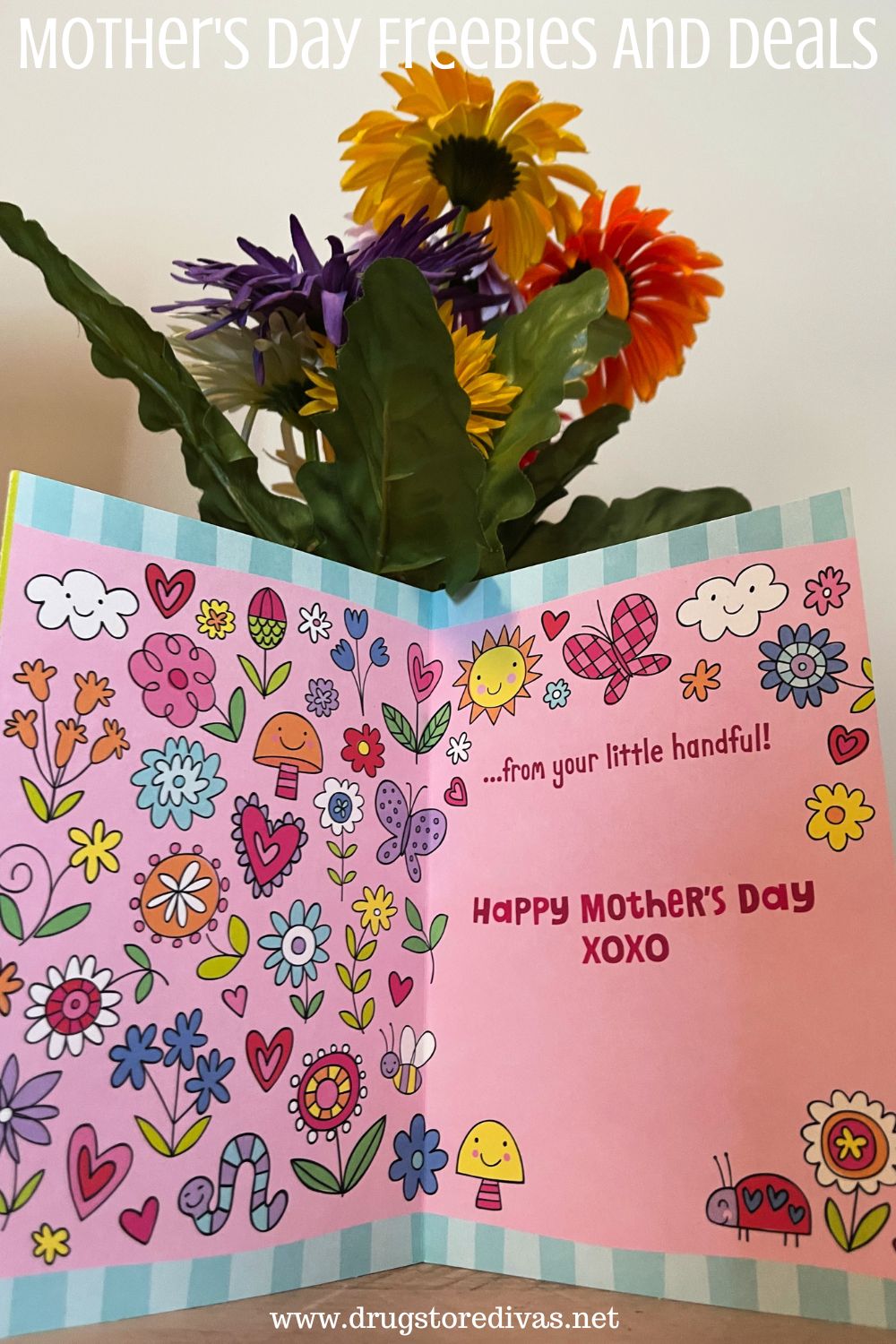 A Mother's Day card in front of flowers with the words 
