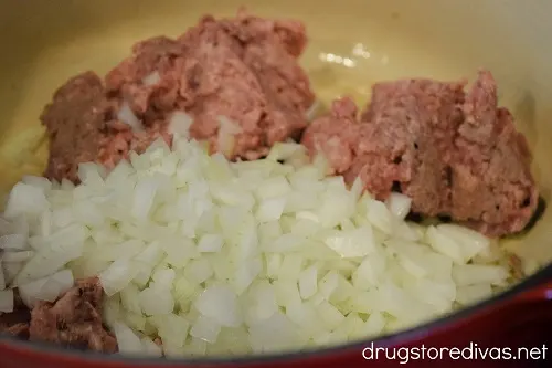 Ground sausage and diced onion in a Dutch oven.