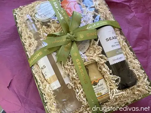 A gift box filled with olive oil, vinegar, salt, mustard, and other cooking ingredients.