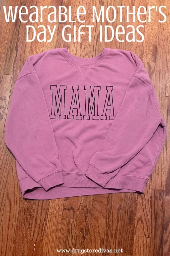 A purple sweatshirt with the word MAMA on it on a wooden floor and the words "Wearable Mother's Day Gift Ideas" digitally written above it.