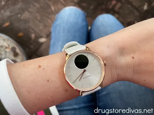 A white and gold watch on a woman's wrist.