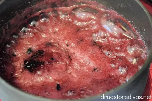Homemade blueberry jam boiling on the stove.