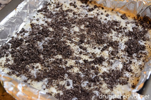 Oreo crumbles on top of Oreo Fudge in a square pan.