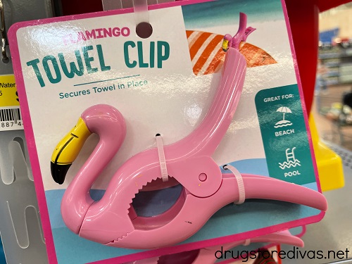 A flamingo shaped beach towel clip on display in a store.