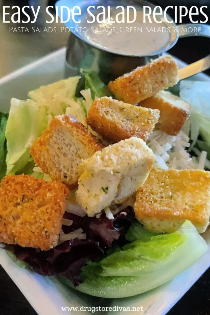 A side salad with croutons on it and dressing in the back with the words "Easy Side Salad Recipes Pasta Salads, Potato Salads, Green Salads & more" digitally written on top.