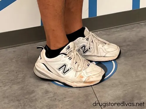 A pair of legs in a pair of New Balance sneakers.