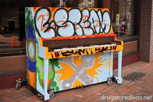A piano with painted graffiti on it.