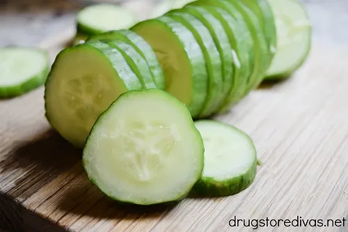 Cucumber sliced on a wooden cutting board.
