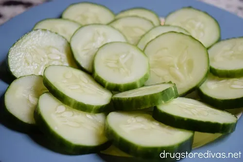 Cucumber slices arranged on a blue plate.
