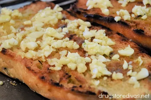 Chopped garlic on top of bread.
