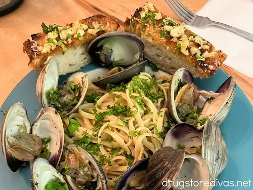Linguine with clams on a plate with garlic bread.
