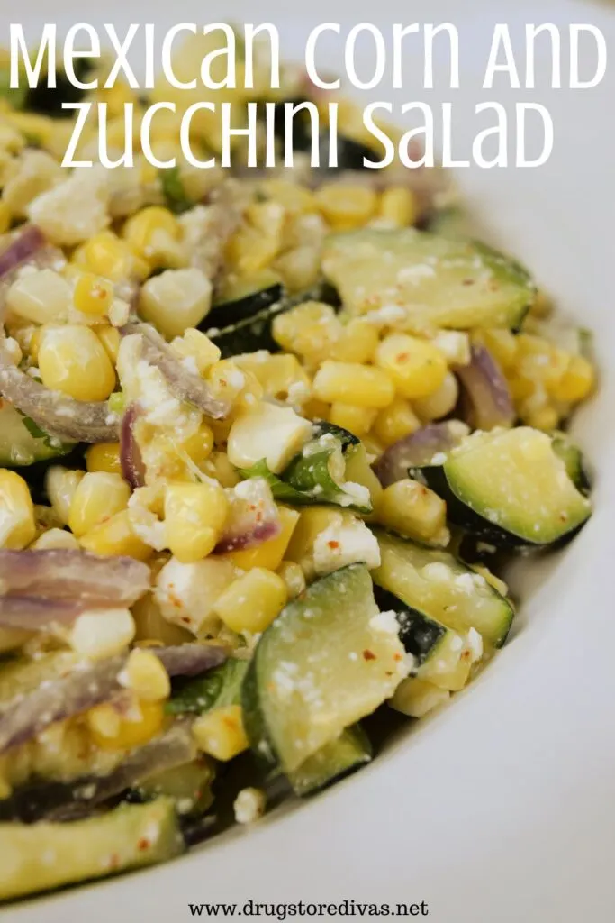 Corn, zucchini, red onion, and white cheese mixed in a bowl with the words "Mexican Corn And Zucchini Salad" digitally written on top.