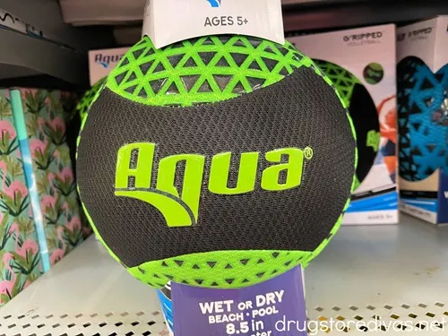 A green and black pool volleyball with the word "Aqua" on it on a store shelf.