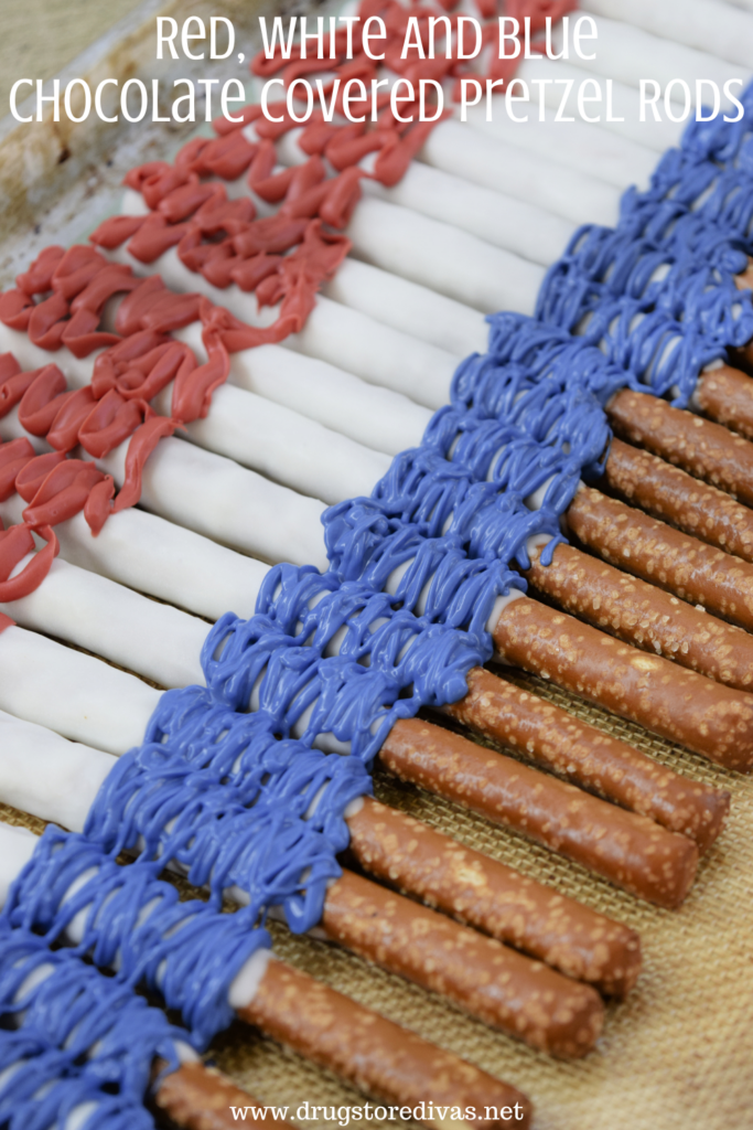 Red, white, and blue chocolate covered pretzels across a silicone baking mat with the words "Red, White, And Blue Chocolate Covered Pretzel Rods" digitally written above them.