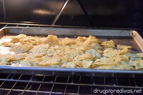Tortilla chips on a baking sheet in the oven.