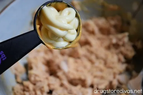 A tablespoon of mayo over tuna fish in a bowl.