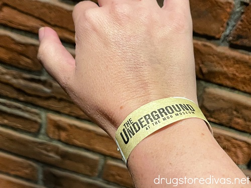 A hand and arm with a wristband that says "The Underground" on it.