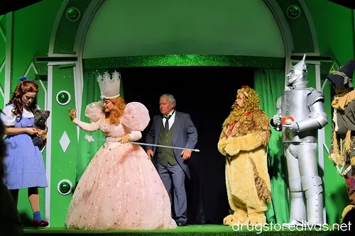 Glinda the Good Witch, Dorothy, the Cowardly Lion, the Wizard, and the Scarecrow on stage at the Land of Oz theme park.
