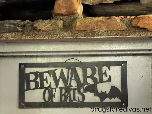 A "beware of bats" sign hanging on a door at the entrance of Linville Caverns.