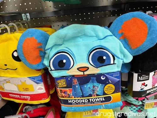 A blue hooded towel designed to look like a Star Wars character on a peg in a store, with a Pikachu hooded towel behind it.