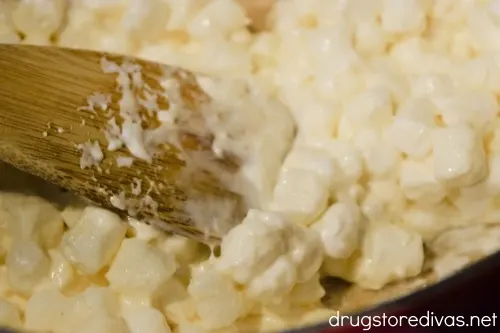 A wooden spoon stirring melting marshmallows.