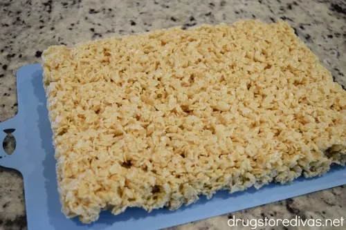 Rice Krispies Treats on a blue cutting board.