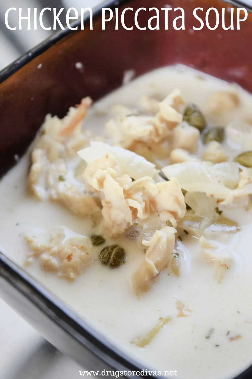 A white soup with chicken and capers showing in a red bowl with the words 