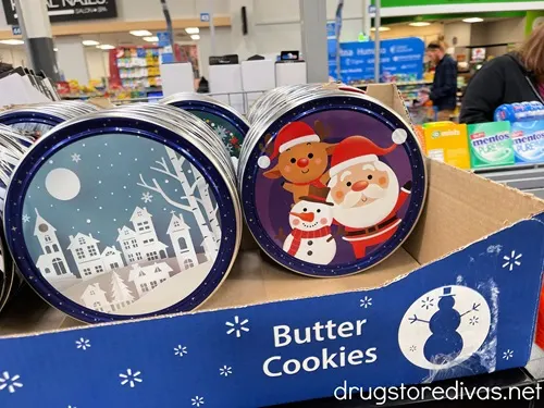 Two Christmas themed cookie tins on the shelf at a store.