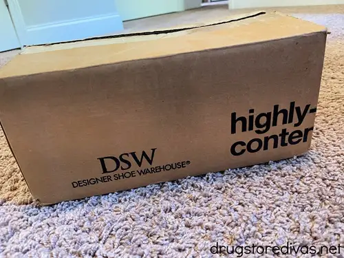 A box from DSW Shoe Wearhouse on a carpeted floor.
