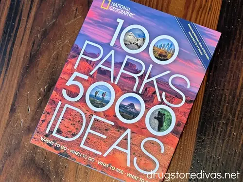 A book titled "100 Parks 5000 Ideas" on a wooden table.