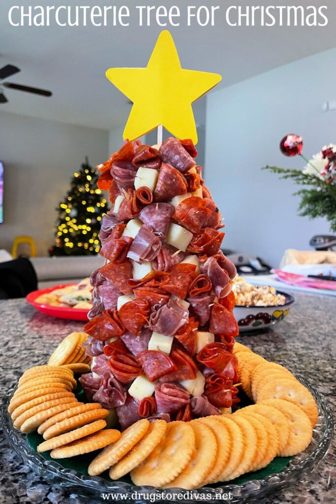 A tree filled with cheese and meat, surrounded by Ritz crackers, with a star on top and the words "Charcuterie Tree For Christmas" digitally written on top.
