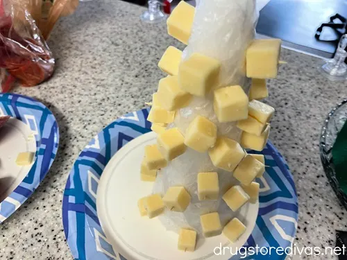 A foam cone with cheese cubes around it.
