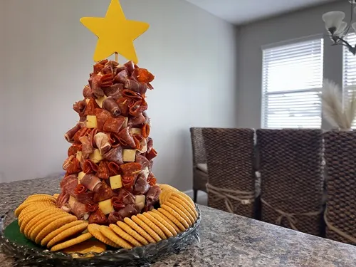 A Charcuterie Christmas Tree with Ritz crackers around it on in a kitchen.