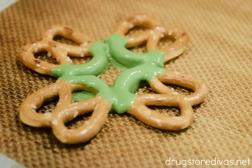 Four mini pretzel twists in a circle, with green melted chocolate in the middle.