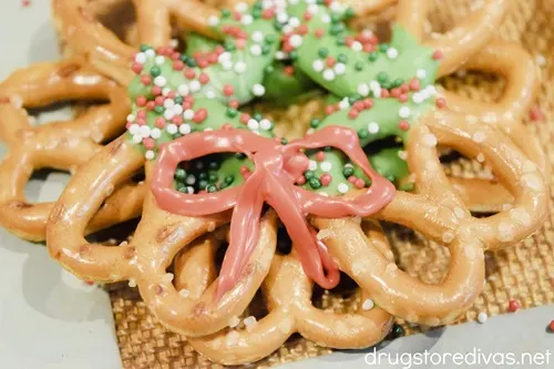 A Christmas pretzel wreath with a red ribbon on it.