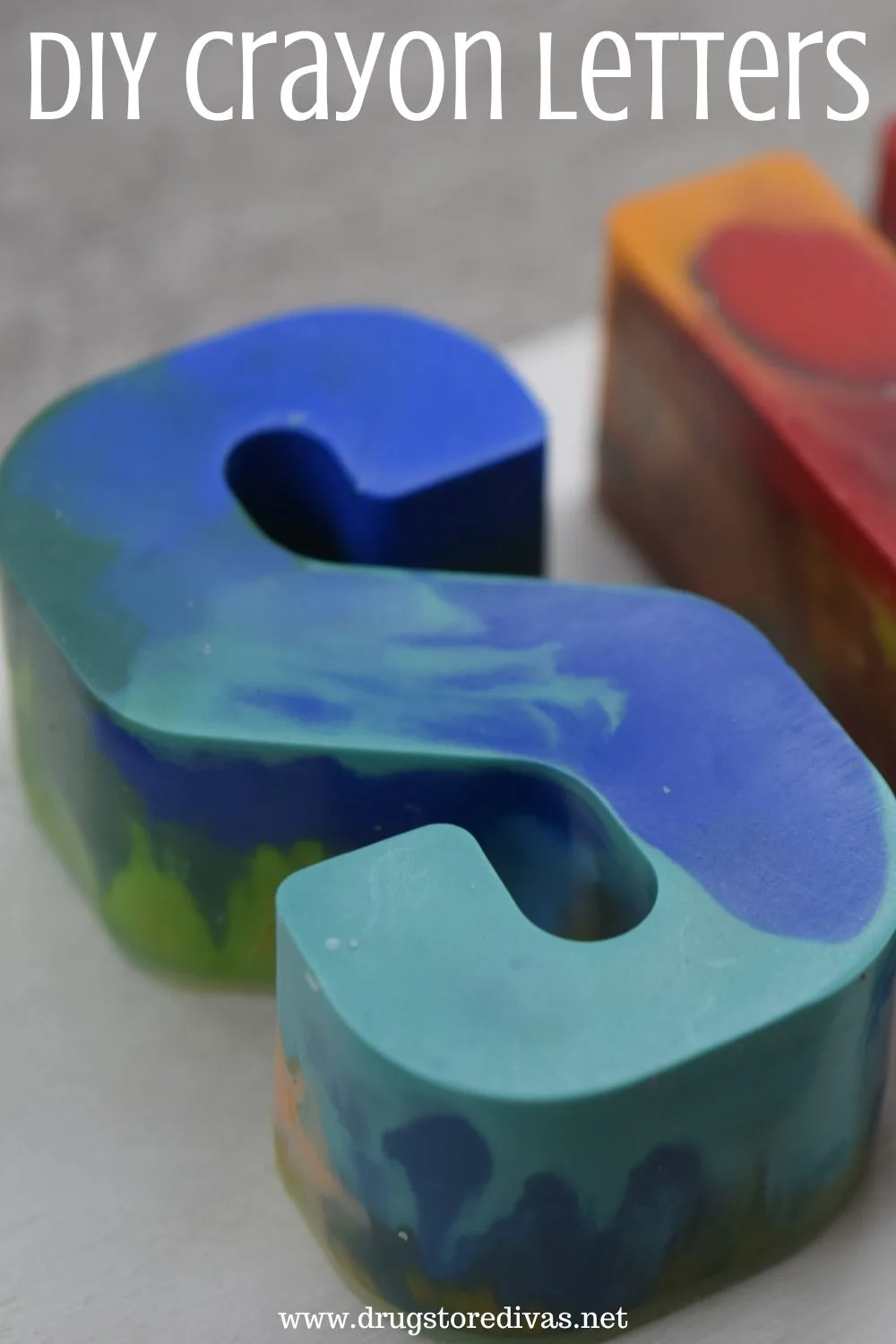 A blue and green crayon in the shape of a letter S with the words 