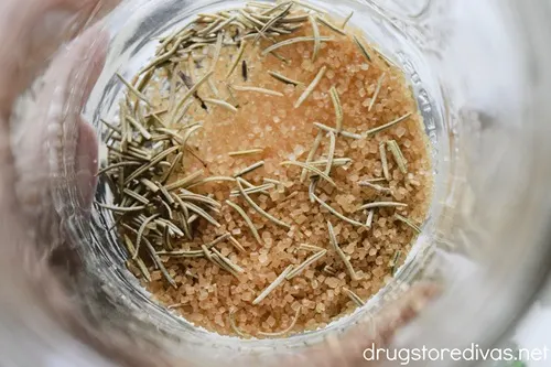 Sugar and rosemary in the bottom of a mason jar.