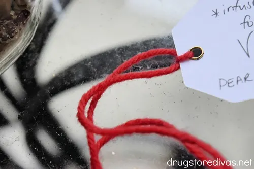 A red piece of yarn on the end of a white gift tag.