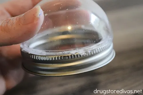 A snow globe top glued to a mason jar ring.