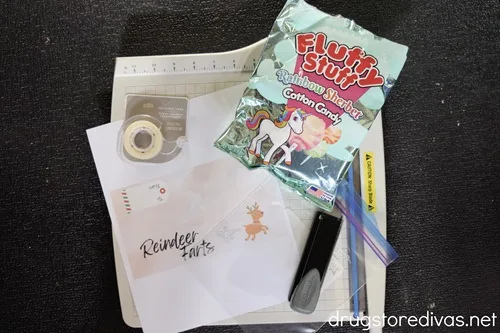 A paper trimmer, tape, printable, bag of cotton candy, stapler, and plastic bag.