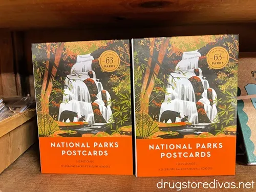 Two boxes of National Parks postcards on a shelf in a store.