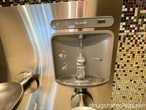 A water bottle being filled up in an automatic dispenser.